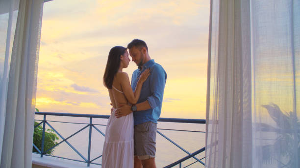 istock Romantic sunset on a patio. Couple hugging and enjoying the view 1358041285