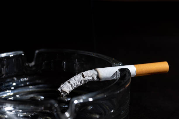 istock Ashtray and smoking cigarette on black background. 1358042104