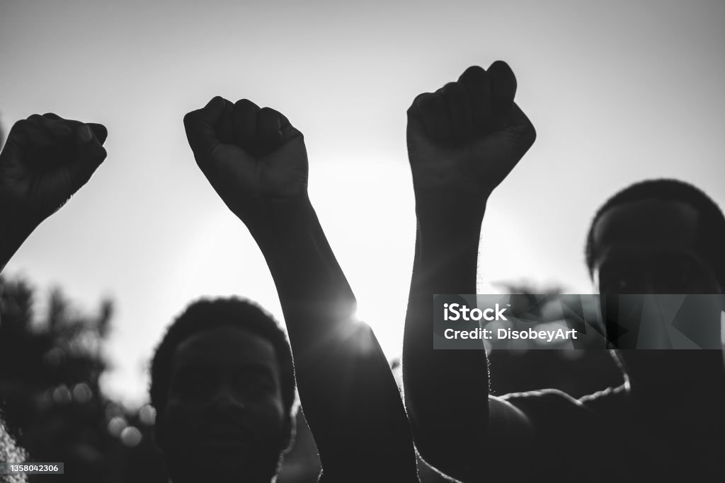 Black demonstrator people holding hands against racism - Focus on civil fists - Black and white edit Protest Stock Photo