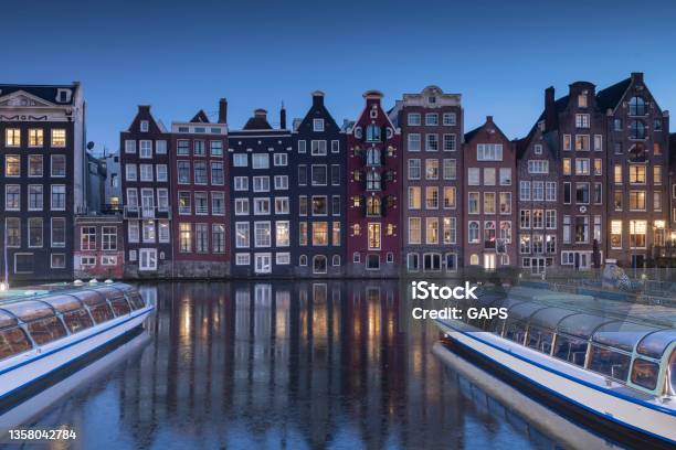 Sightseeing Boats And Canal Houses On Damrak In The City Centre Of Amsterdam At Dusk Stock Photo - Download Image Now
