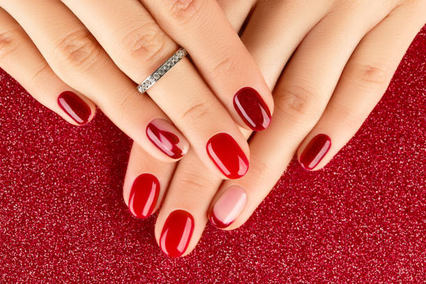 istock Female hands with manicure on red background 1358045653