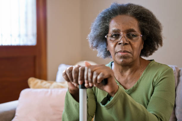 elderly woman with walking cane at home - women sadness african ethnicity african descent imagens e fotografias de stock