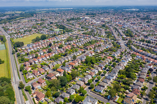 Aerial drone photo of a typical British housing estate located in the town of Bournemouth in the summer time showing rows of suburban houses, gardens and streets