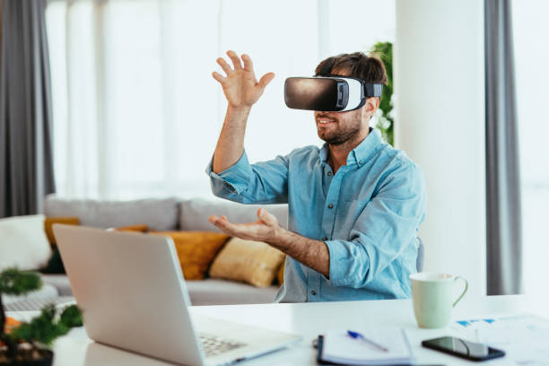 istock Young adult in smart casual shirt working from home, using VR headset 1358049104