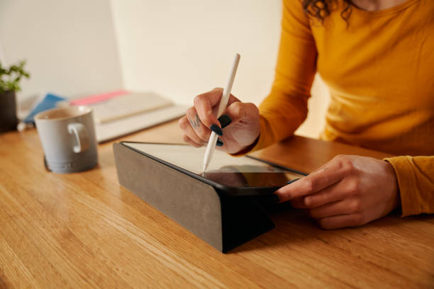 mujer afroamericana dibujando en su tableta digital tomando notas - ewan fotografías e imágenes de stock