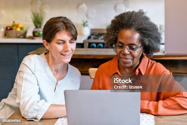 Healthcare Worker Teaching Laptop To Senior Woman Stock Photo - Download Image Now - Community Outreach, Senior Adult, African-American Ethnicity