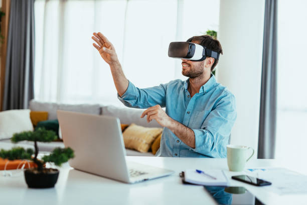 istock Young adult in smart casual shirt working from home, using VR headset 1358049234