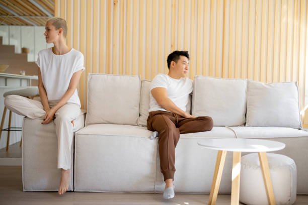 istock Couple using smartphones on sofa at home 1358049261