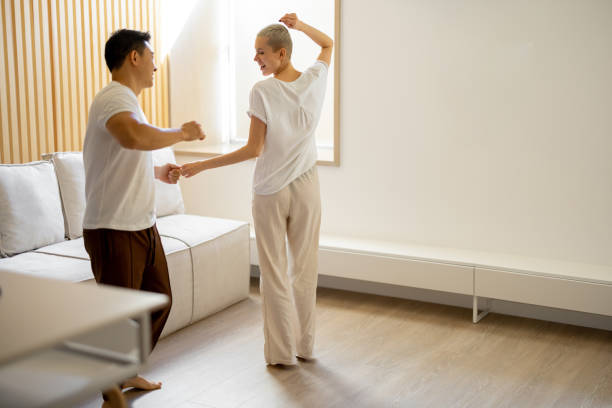 istock Multiracial couple dancing while resting at home 1358049473
