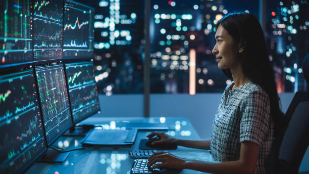 Portrait of a Financial Analyst Working on Computer with Multi-Monitor Workstation with Real-Time Stocks, Commodities and Exchange Market Charts. Businesswoman at Work in Investment Broker Agency. retrato de un analista financiero que trabaja en una computadora con una estación de trabajo de múltiples monitores con acciones, materias primas y gráficos del mercado de divisas en tiempo real. empresaria en el trabajo en la agencia de corredores de i