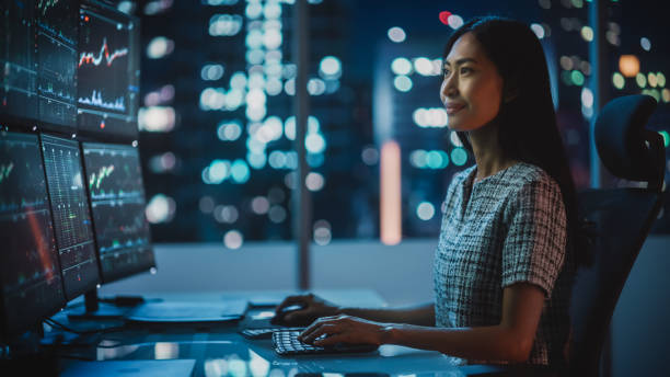 Portrait of a Financial Analyst Working on Computer with Multi-Monitor Workstation with Real-Time Stocks, Commodities and Exchange Market Charts. Businesswoman at Work in Investment Broker Agency. Portrait of a Financial Analyst Working on Computer with Multi-Monitor Workstation with Real-Time Stocks, Commodities and Exchange Market Charts. Businesswoman at Work in Investment Broker Agency. hedge fund stock pictures, royalty-free photos & images