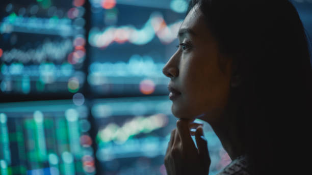 Close Up Portrait of Financial Analyst Working on Computer with Multi-Monitor Workstation with Real-Time Stocks, Commodities and Exchange Market Charts. Businesswoman at Work in Investment Agency. retrato de cerca del analista financiero que trabaja en la computadora con una estación de trabajo de múltiples monitores con acciones, materias primas y gráficos del mercado de divisas en tiempo real. empresaria en el trabajo en la agencia de inversion