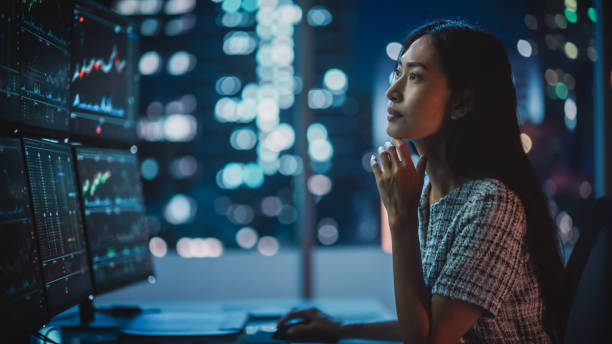 istock Portrait of a Financial Analyst Working on Computer with Multi-Monitor Workstation with Real-Time Stocks, Commodities and Exchange Market Charts. Businesswoman at Work in Investment Broker Agency. 1358050002