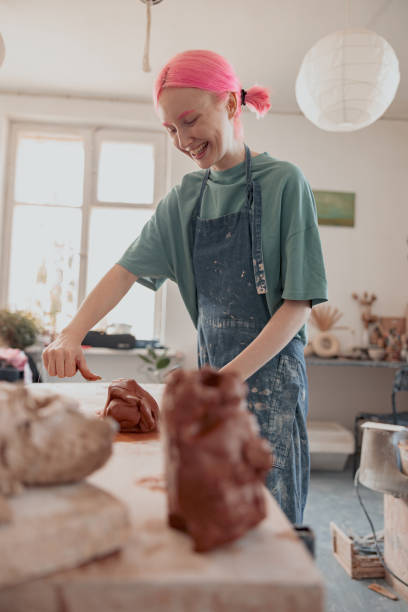 istock Happy woman potter working with clay in workroom 1358050893