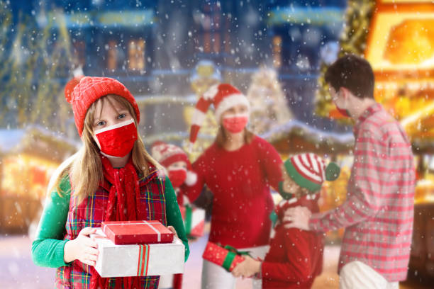 family in face mask at christmas fair. stop covid. - balloon child winter snow imagens e fotografias de stock