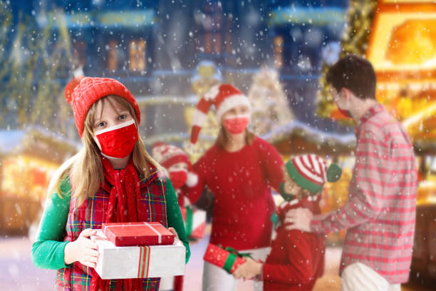 семья в маске на рождественской ярмарке. остановите ковид. - balloon child winter snow стоковые фото и изображения