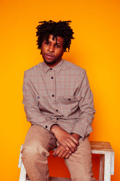 istock young handsome african american guy student posing cheerful and gesturing on yellow background, lifestyle people concept 1358052893