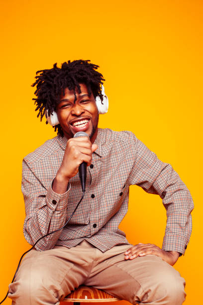 istock young handsome african american guy student posing cheerful and gesturing on yellow background, lifestyle people concept 1358053081