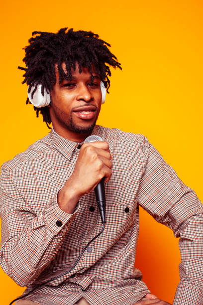istock young handsome african american guy student posing cheerful and gesturing on yellow background, lifestyle people concept 1358053084