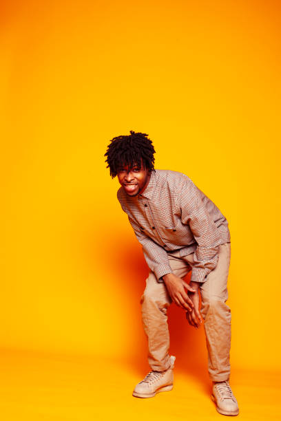 istock young handsome african american guy student posing cheerful and gesturing on yellow background, lifestyle people concept 1358053097