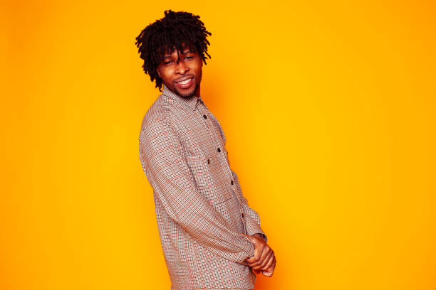istock young handsome african american guy student posing cheerful and gesturing on yellow background, lifestyle people concept 1358053627