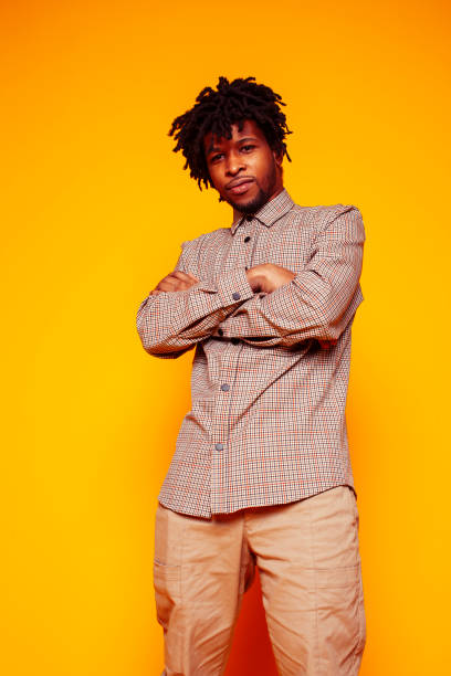 istock young handsome african american guy student posing cheerful and gesturing on yellow background, lifestyle people concept 1358053656