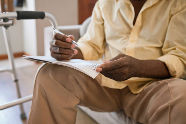 istock Senior man solving crossword puzzle at home 1358054985