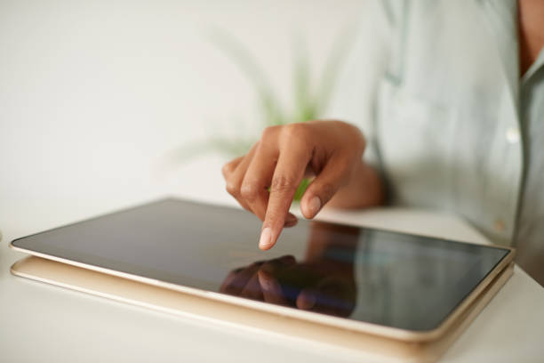 istock Shot of an unrecognizable person using a digital tablet at home 1358055477