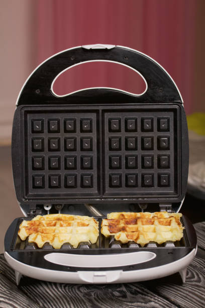 istock Waffle maker with waffles. On black pine boards. Close-up shot. 1358057062