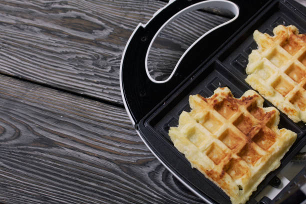 istock Waffle maker with waffles. On black pine boards. Close-up shot. 1358057063