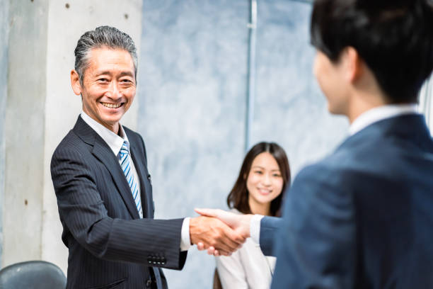 istock Business people shaking hands with smiling faces 1358058906