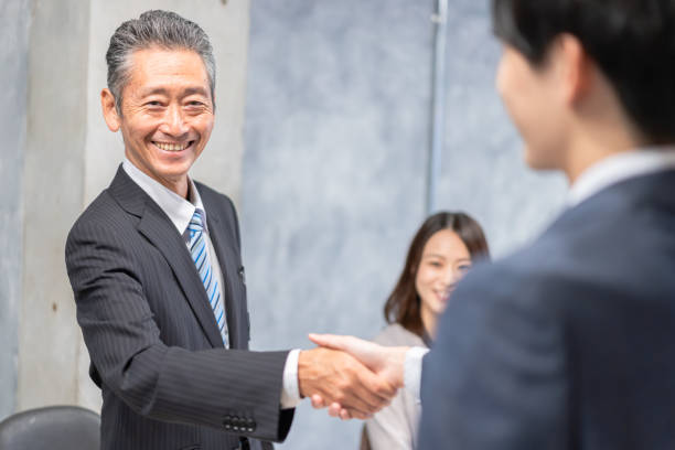 istock Business people shaking hands with smiling faces 1358058909