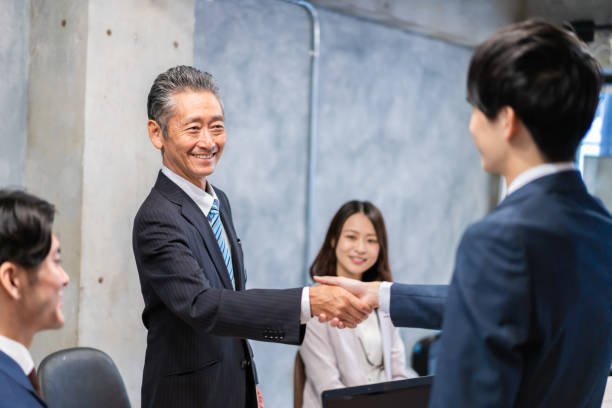 istock Business people shaking hands with smiling faces 1358058920