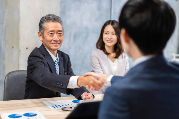 istock Business people shaking hands with smiling faces 1358058942