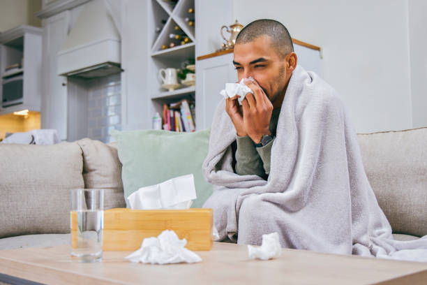 istock Shot of a young man blowing his nose during a cold 1358069620