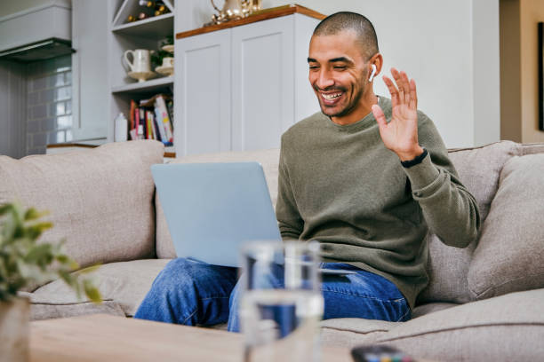 istock Shot of a young man using his laptop to make a video call while working from home 1358070516