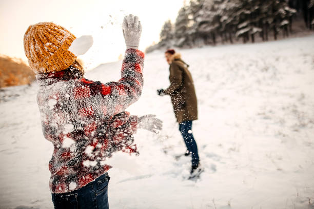 istock Winter Fun - Young Couple Having Snowball Fight 1358070767