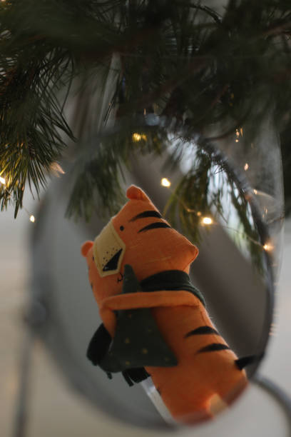 cute soft toy tiger with decorations on a cozy Christmas or New Year background. symbol of 2022, oriental calendar concept cute soft toy tiger - symbol of 2022, oriental calendar concept. High quality photo oriental spruce stock pictures, royalty-free photos & images