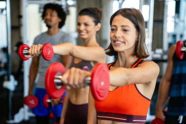 istock Group of young people doing exercises in gym 1358077099