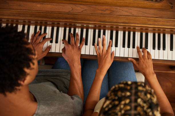 Young couple playing a musical composition together on a piano