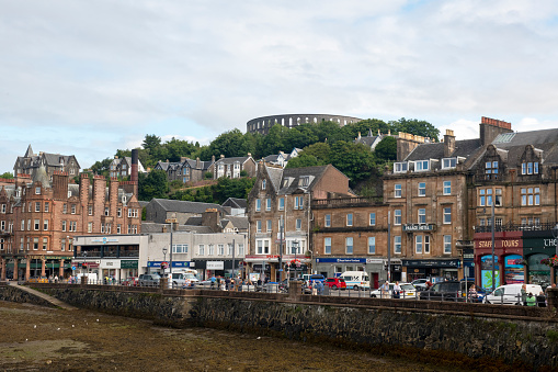 Oban, Scotland, UK - August 22nd 2021: Oban is often referred to as the 'Gateway to the Isles' because of the numerous ferries that leave there for surrounding islands such as Kerrera, Lismore, Mull, Iona, and Coll.  It also serves as a marina for pleasure craft and a harbour for fishing vessels. McCaig’s Tower is a prominent feature of the landscape.  In the shape of an amphitheatre, the monument is positioned high above the town.