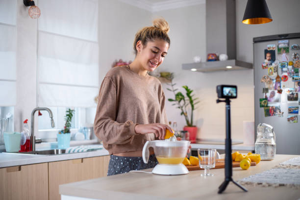 istock Young beautiful woman vlogging  and  making  fresh lemonade 1358078701