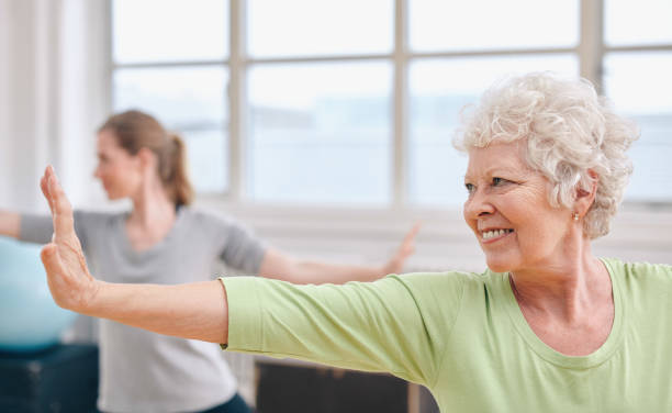 istock Happy senior woman practicing yoga in her gym class 1358079692