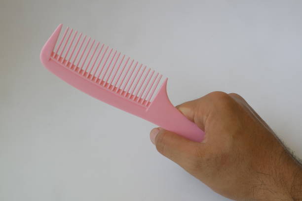 hands holding comb pink on the white background photo