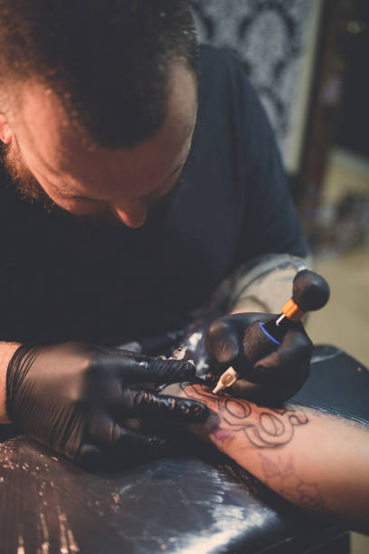 istock Tattooist makes a tattoo 1358080036