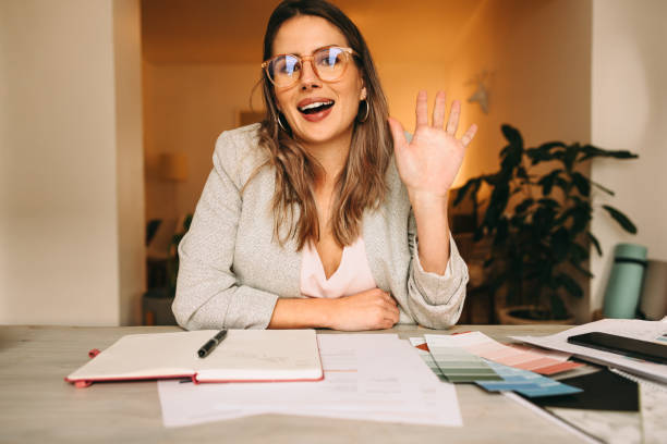 istock Young interior designer waving her hand during a video call 1358081320