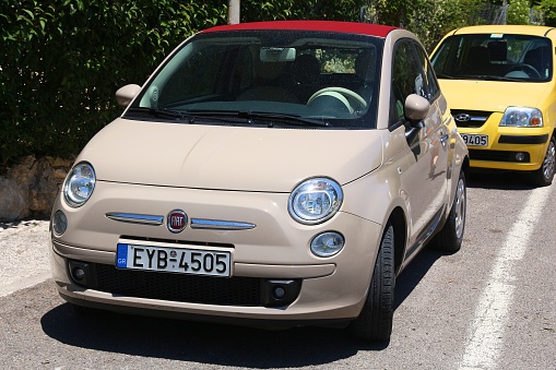 Fiat 500 small city car parked in Corfu Island, Greece. With 566 registered vehicles per 1000 inhabitants Greece is below EU average (573).