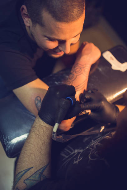 istock Artist making tattoo on customer's hand 1358082537