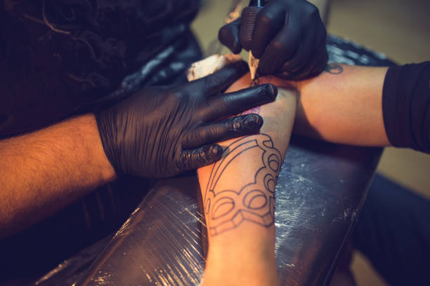 istock Artist making tattoo on customer's hand 1358082791