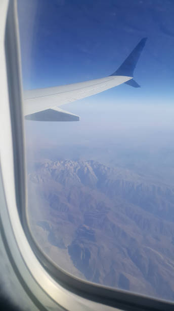 istock Looking through window aircraft during flight in wing with a nice blue sky 1358083125